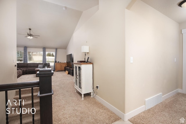hallway featuring visible vents, carpet floors, and lofted ceiling