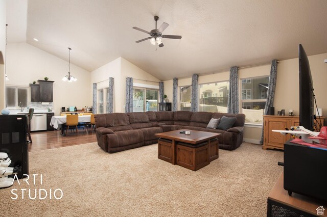 living area with light carpet, ceiling fan with notable chandelier, and vaulted ceiling