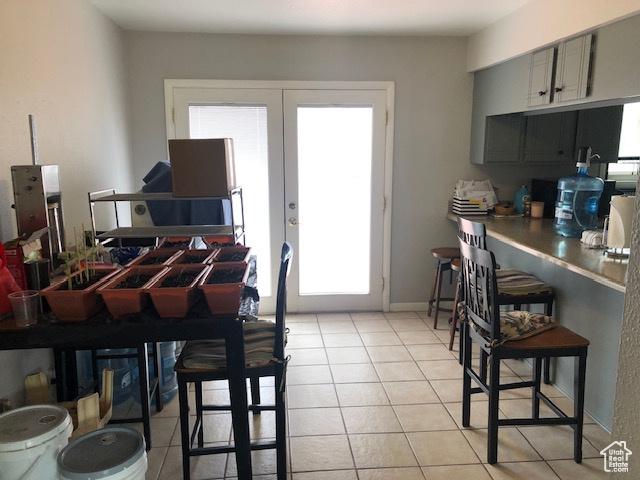 dining space with french doors and light tile patterned flooring