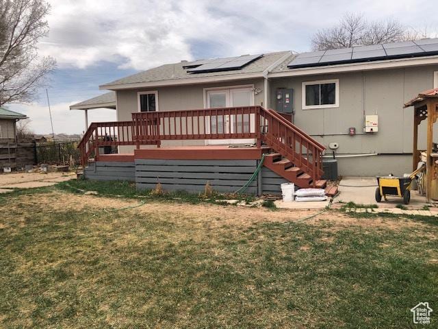 rear view of property with stairs, a deck, and a lawn