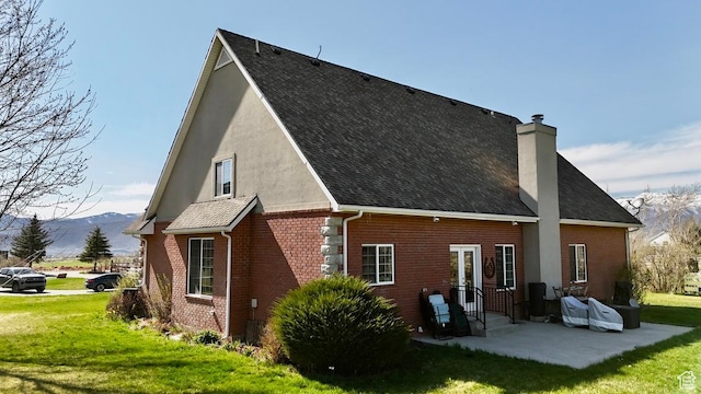3193 S Southfield Rd W, Daniel, UT 84032 - rear view of property featuring brick siding, a mountain view, a lawn, and a patio area