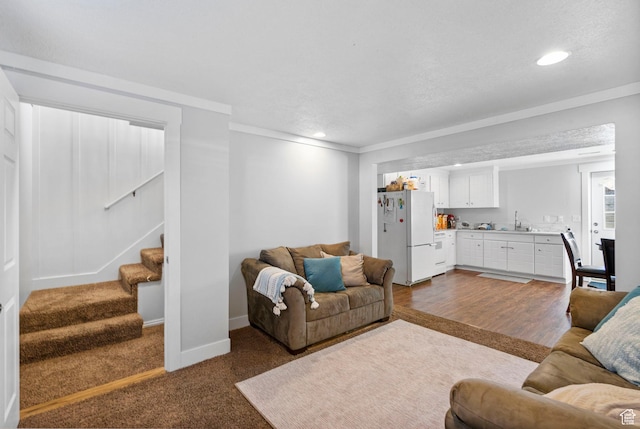 1055 W 325 N, Hyrum, UT 84319 - living room with recessed lighting, stairs, dark carpet, and crown molding
