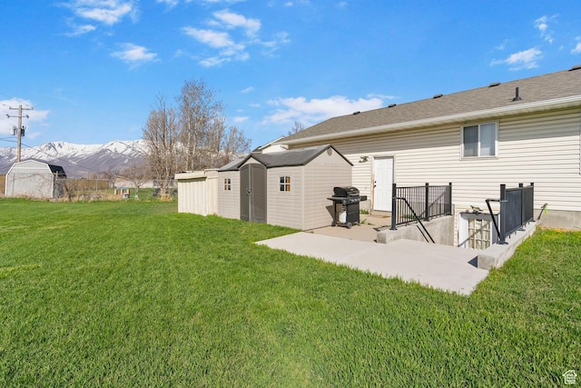 1055 W 325 N, Hyrum, UT 84319 - rear view of house with a yard, a mountain view, an outbuilding, and a storage unit