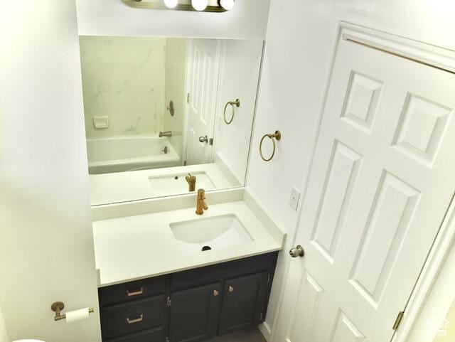 full bath featuring vanity and a washtub