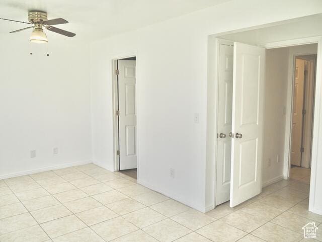 unfurnished room featuring light tile patterned floors, ceiling fan, and baseboards
