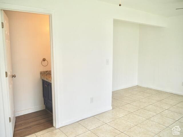 unfurnished room with light tile patterned floors and baseboards