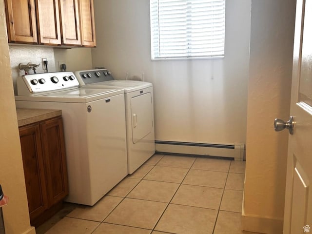 clothes washing area featuring cabinet space, light tile patterned floors, independent washer and dryer, and a baseboard heating unit