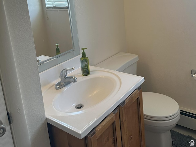 bathroom featuring a textured wall, toilet, vanity, and a baseboard heating unit