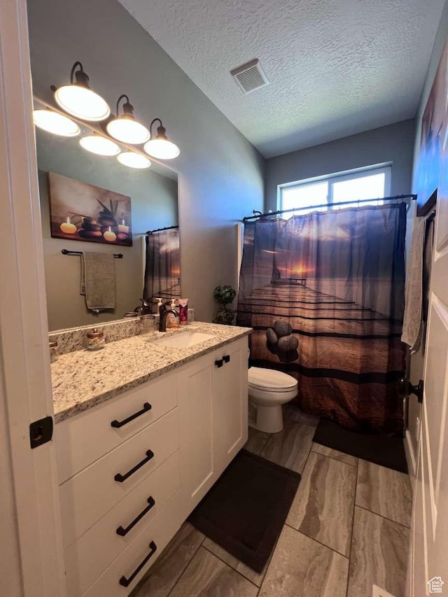 full bath with a textured ceiling, toilet, visible vents, curtained shower, and vanity