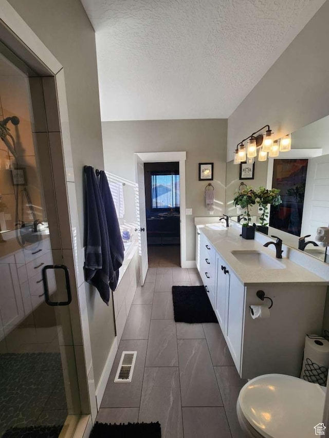 bathroom with a textured ceiling, a sink, visible vents, and a stall shower