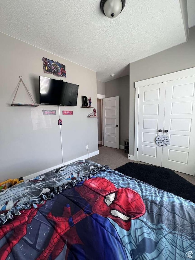 carpeted bedroom featuring baseboards, a textured ceiling, and a closet