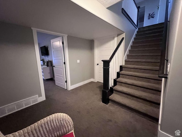 staircase with baseboards and carpet floors