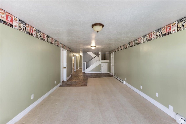 carpeted spare room with a baseboard radiator, baseboards, a textured ceiling, and stairs