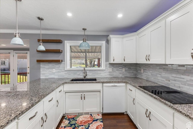 kitchen featuring white dishwasher, a sink, black electric stovetop, and crown molding