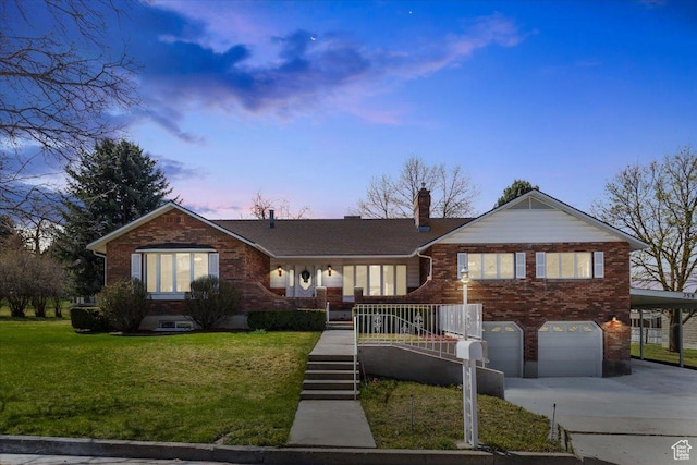 ranch-style home with a garage, brick siding, driveway, and a lawn