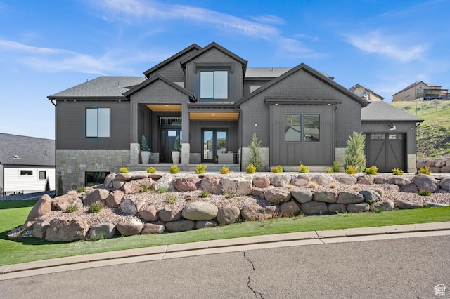 view of front of property featuring an attached garage and stone siding