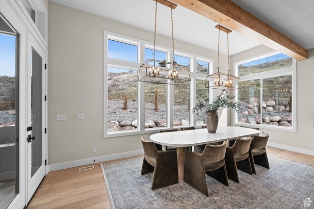 dining room featuring an inviting chandelier, beamed ceiling, light wood-style flooring, and visible vents