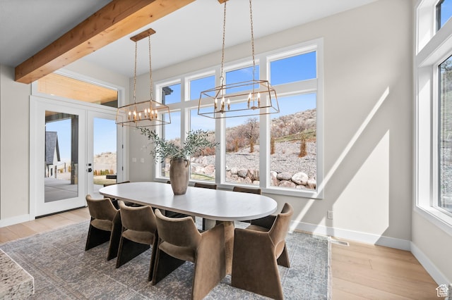 dining space featuring baseboards, light wood-type flooring, a notable chandelier, and visible vents
