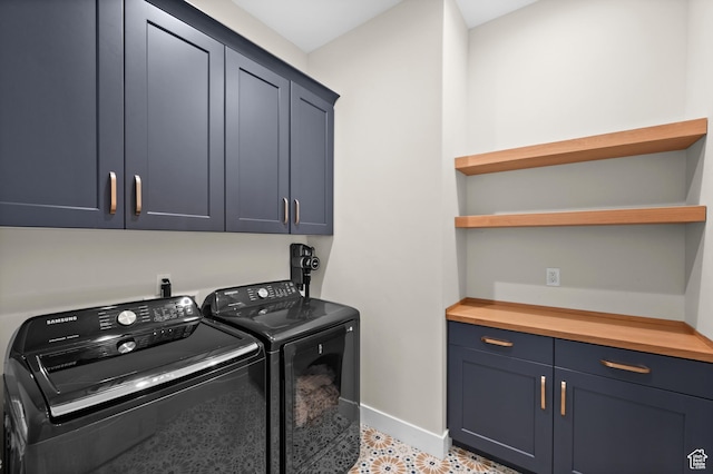 laundry area with baseboards, cabinet space, and washer and clothes dryer
