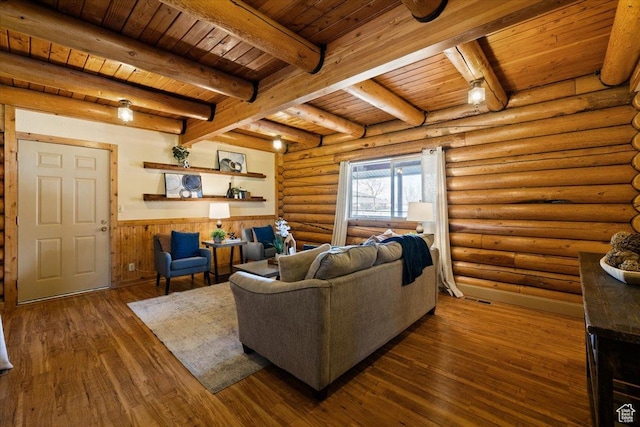 living area featuring dark wood finished floors, wooden ceiling, wainscoting, and beamed ceiling