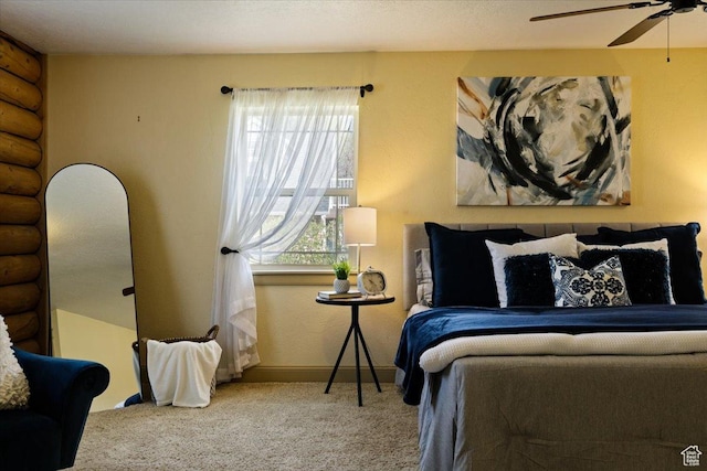 carpeted bedroom with ceiling fan, baseboards, and rustic walls