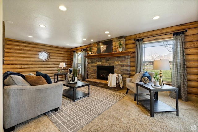 living room featuring a textured ceiling, rustic walls, a stone fireplace, and recessed lighting