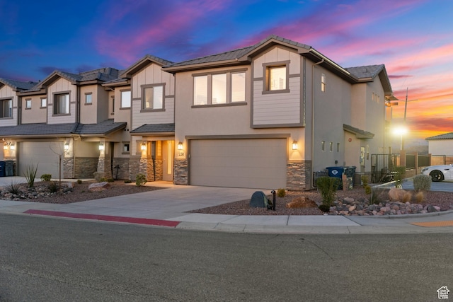 238 N 2020 W # 69, Hurricane, UT 84737 - view of property with stucco siding, fence, stone siding, an attached garage, and driveway