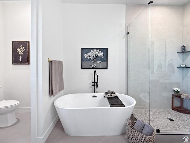 bathroom with a shower stall, tile patterned floors, baseboards, and a soaking tub