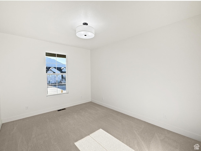 carpeted empty room with visible vents and baseboards