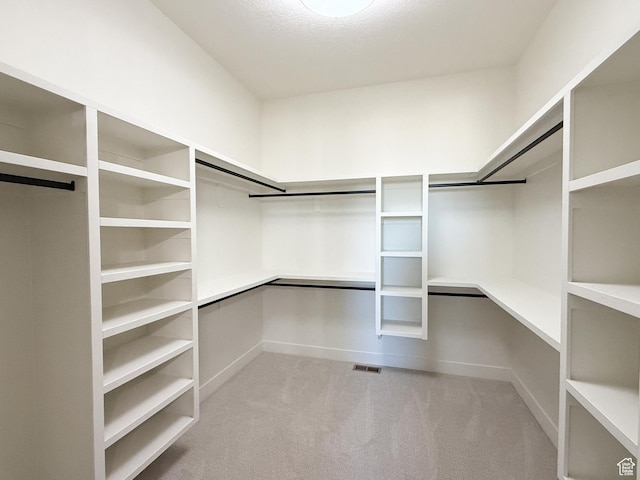 walk in closet featuring visible vents and carpet
