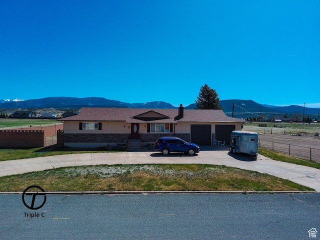 single story home with fence, driveway, a mountain view, and an attached garage