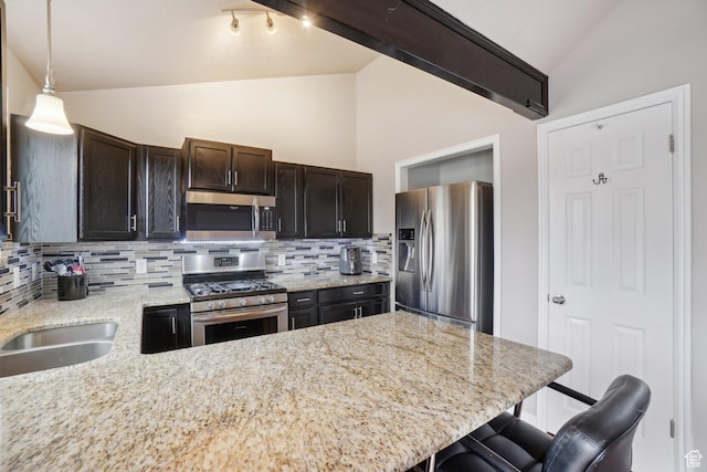 kitchen with lofted ceiling, appliances with stainless steel finishes, and decorative backsplash