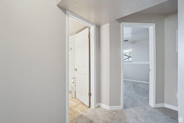 hallway with light carpet and baseboards