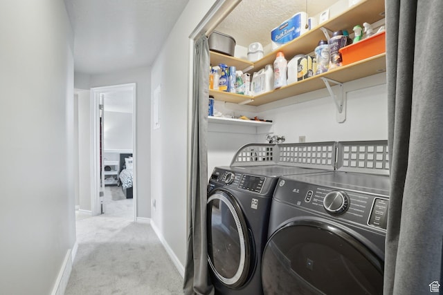 laundry area featuring washing machine and dryer, carpet floors, laundry area, and baseboards