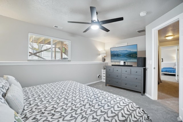 carpeted bedroom with baseboards, visible vents, and ceiling fan