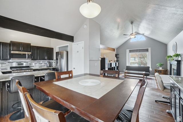 dining area with lofted ceiling, wood finished floors, and a ceiling fan