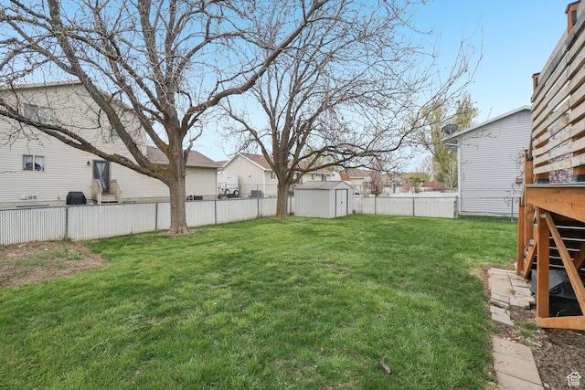 view of yard with a fenced backyard, an outbuilding, a residential view, and a shed