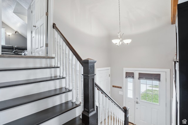 staircase with wood finished floors and a notable chandelier