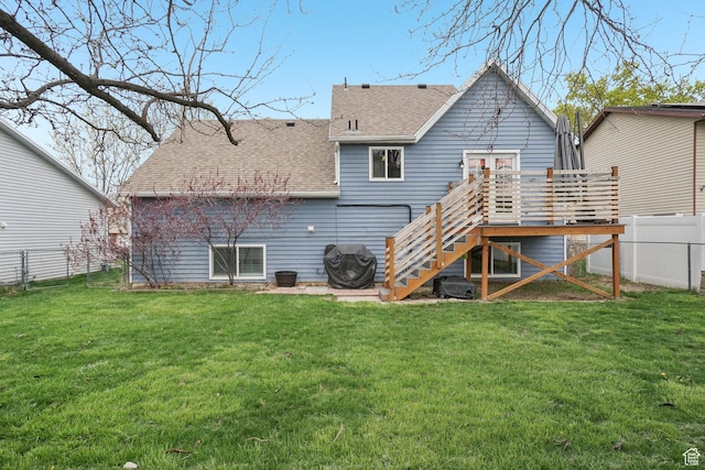rear view of property with stairway, a shingled roof, a fenced backyard, a yard, and a deck