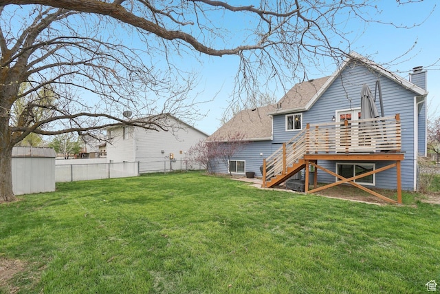 rear view of house featuring a lawn, stairs, fence, and a deck