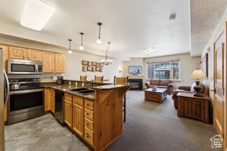 2669 Canyons Resort Dr Unit 207, Park City, UT 84098 - kitchen featuring decorative light fixtures, open floor plan, a peninsula, stainless steel appliances, and a breakfast bar area