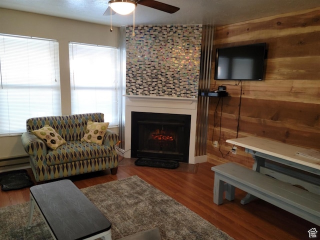 3615 N Wolf Lodge Dr Unit 211, Eden, UT 84310 - living room featuring wood walls, a ceiling fan, wood finished floors, and a lit fireplace