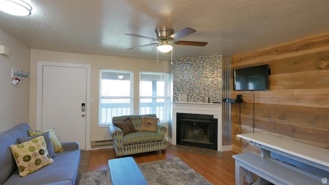 3615 N Wolf Lodge Dr Unit 211, Eden, UT 84310 - living area featuring a baseboard heating unit, wood finished floors, a textured ceiling, and ceiling fan
