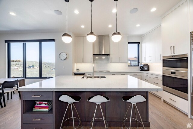 6633 Golden Bear Loop W, Park City, UT 84098 - kitchen with wall chimney range hood, open shelves, a sink, an island with sink, and a kitchen bar