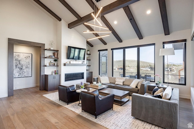 6633 Golden Bear Loop W, Park City, UT 84098 - living room with light wood-type flooring, baseboards, a glass covered fireplace, and beamed ceiling