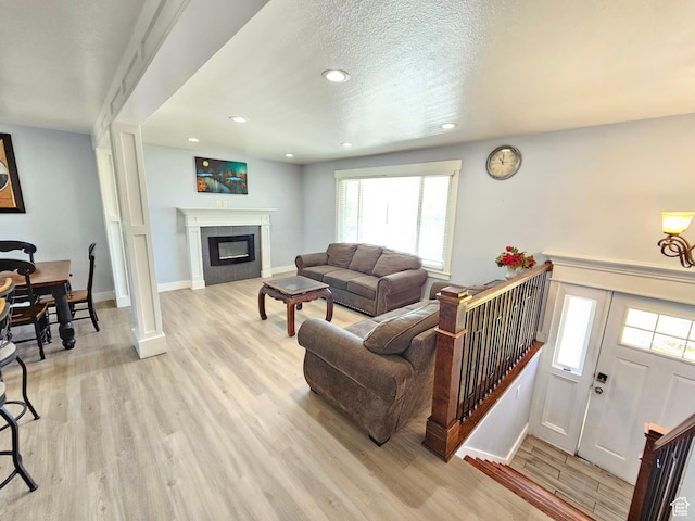 3500 W 6875 S, West Jordan, UT 84084 - living area with light wood-style floors, recessed lighting, baseboards, plenty of natural light, and a tile fireplace