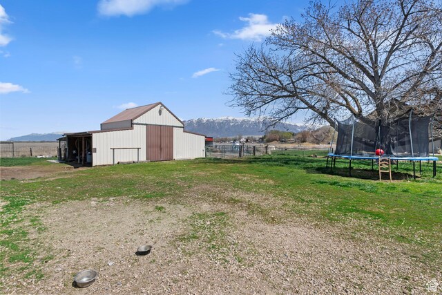 4710 W 2200 N, Plain City, UT 84404 - view of yard featuring an outbuilding, an outdoor structure, fence, a trampoline, and a garage