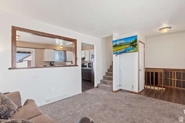4710 W 2200 N, Plain City, UT 84404 - living area with dark colored carpet, stairway, visible vents, and baseboards