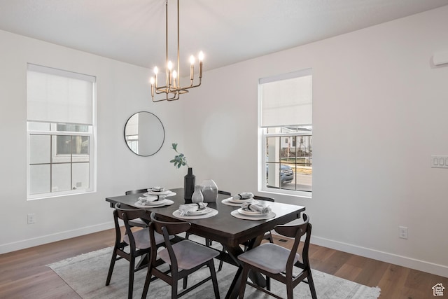 dining room featuring a chandelier, wood finished floors, and baseboards