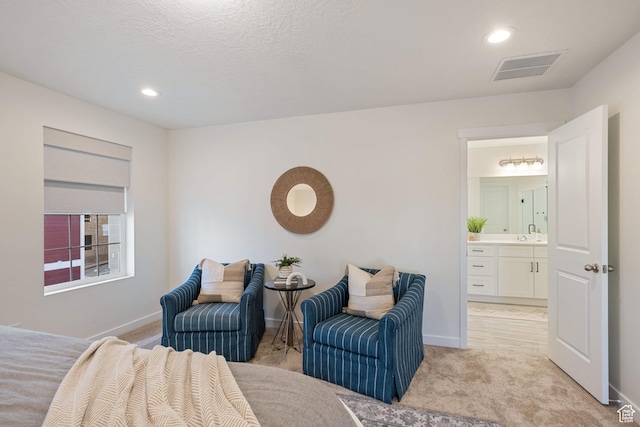 bedroom featuring baseboards, recessed lighting, ensuite bath, visible vents, and light colored carpet